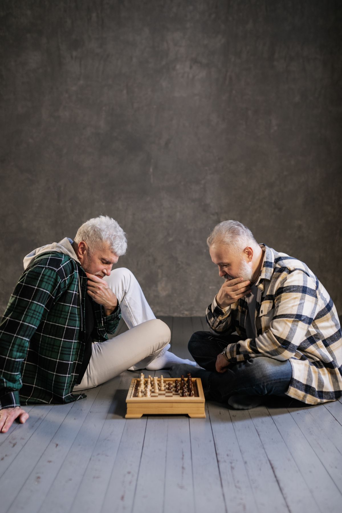 Two senior men playing chess indoors