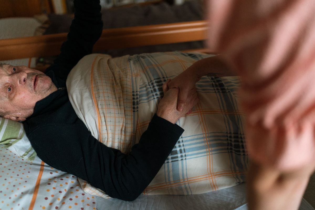 Caregiver holding hands with a senior at home