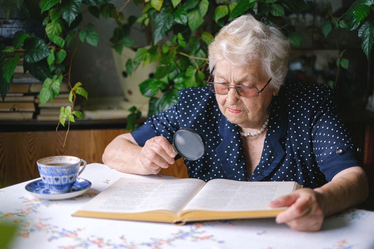 Senior woman reading with a magnifying glass