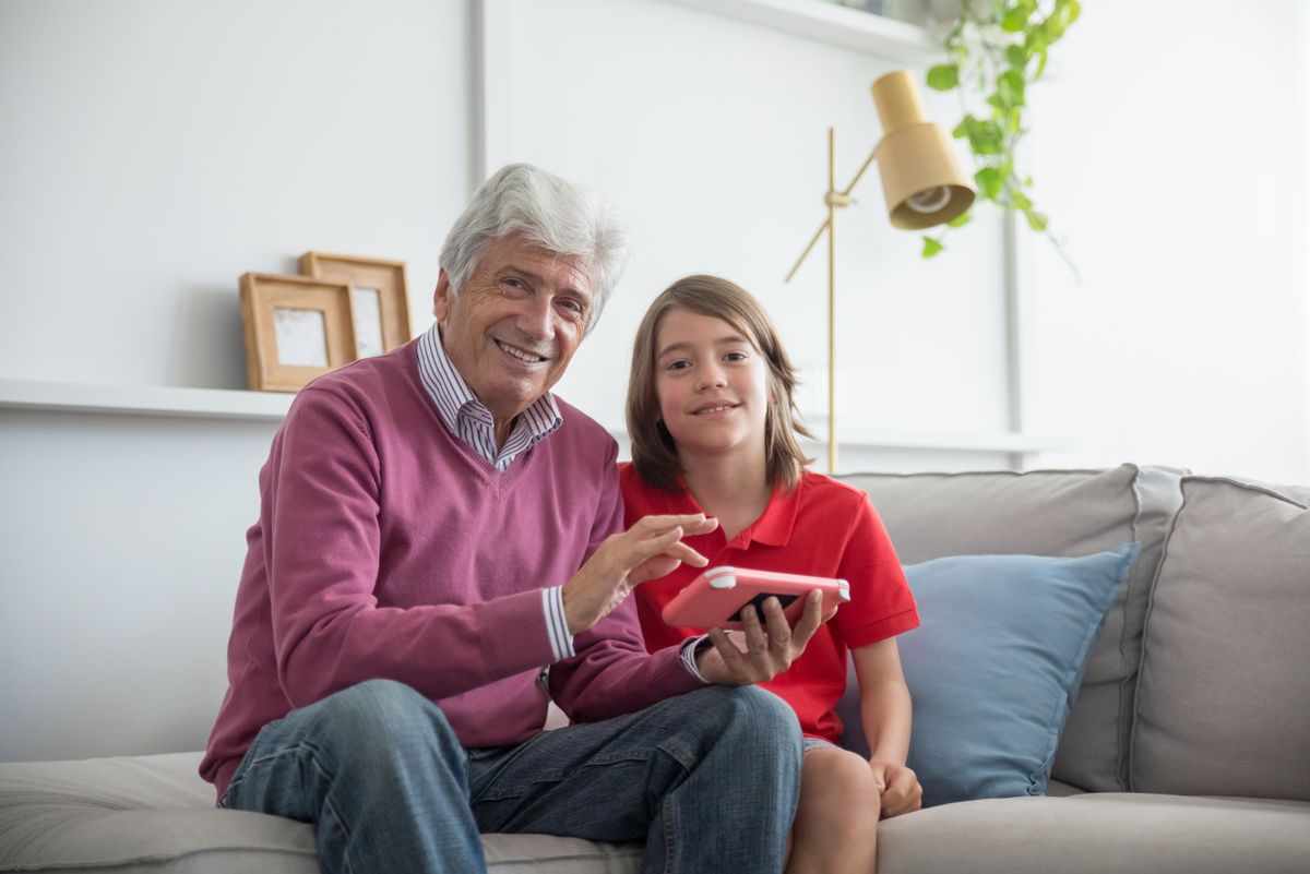 Grandfather and granddaughter using a tablet together